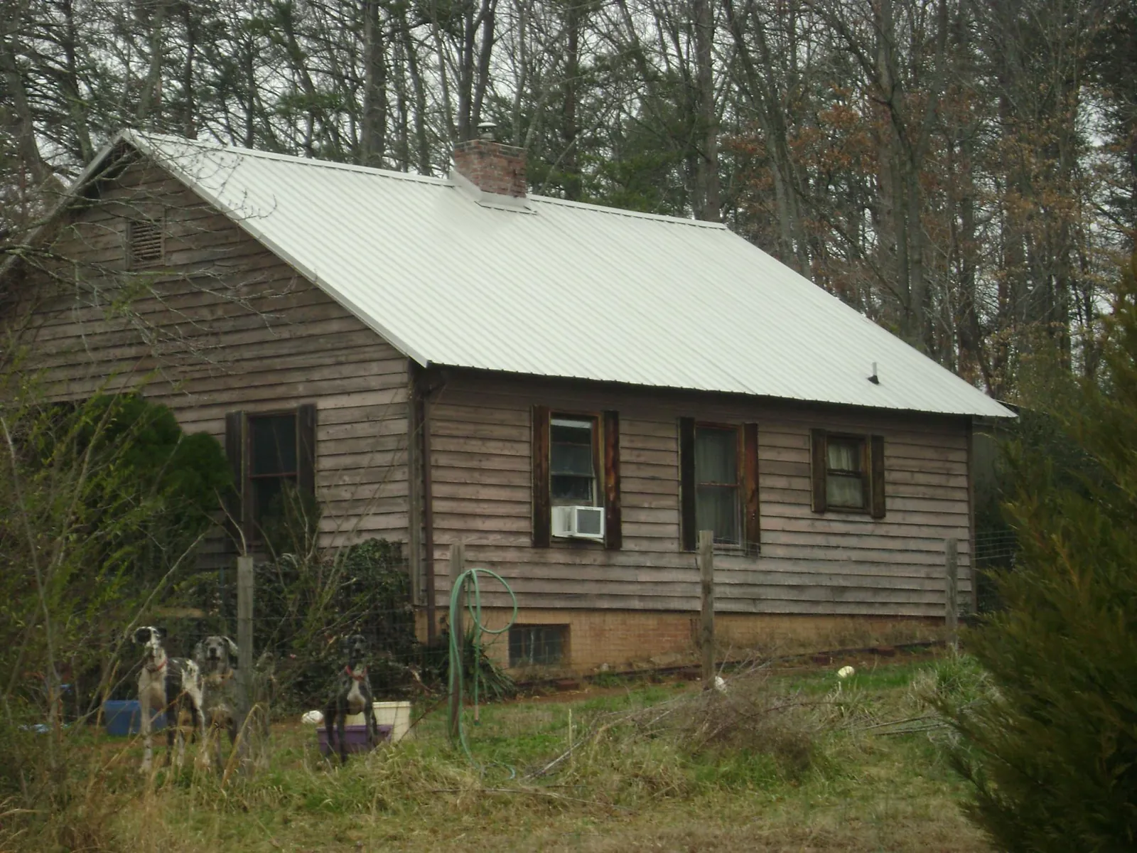 White metal roof on an old wood sided farmhouse, from a Metal Roof Installation job in Hardin